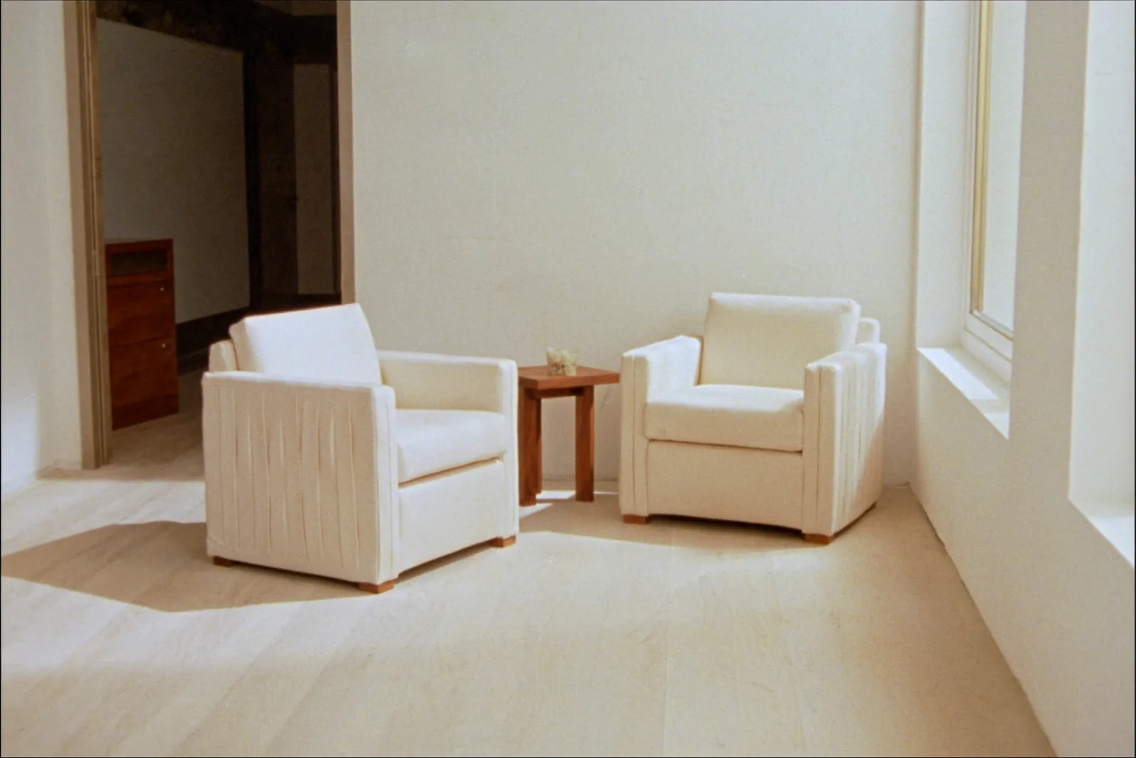 Deux fauteuils se faisant face dans une pièce claire, une table basse entre eux